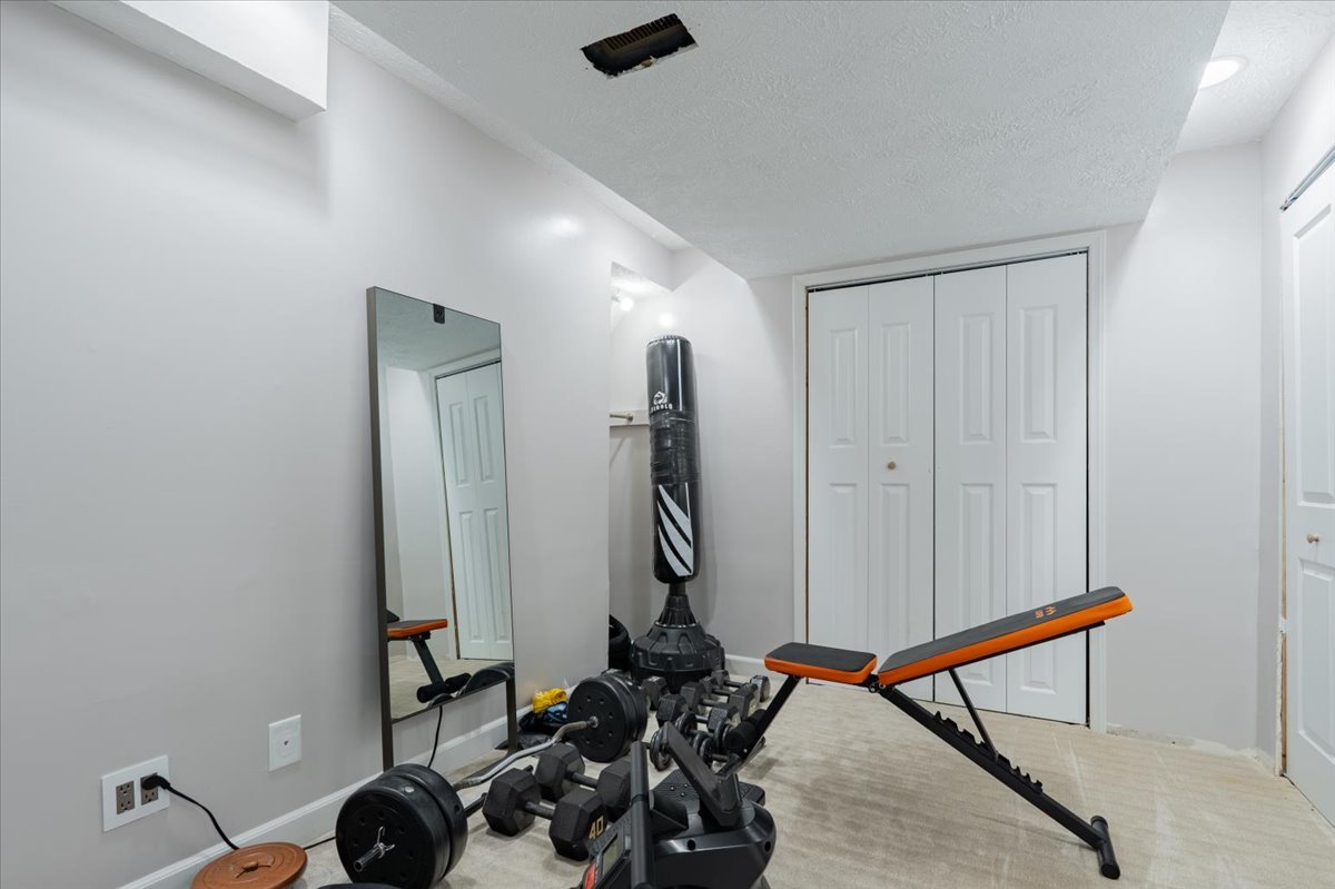 607 Old Farm Road Bloomington, IL 61704 - Photo 32 of 40 a room with gym equipment and wooden floor