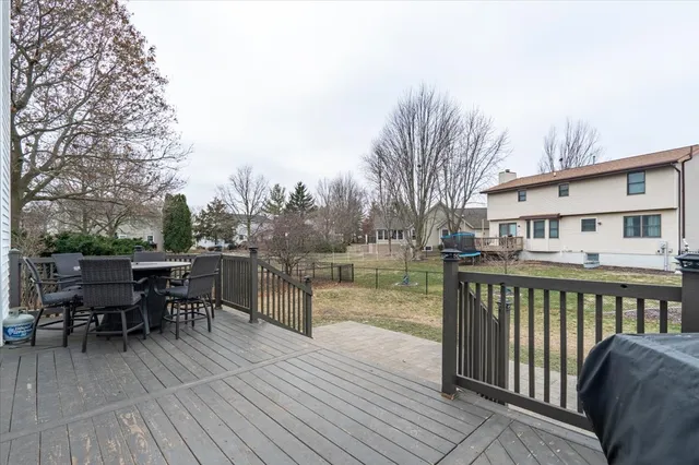 a balcony with wooden floor table and chairs