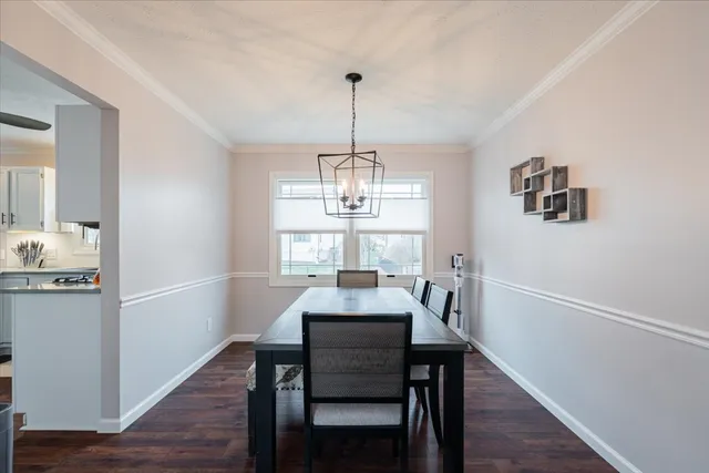 a dining room with furniture a chandelier and wooden floor