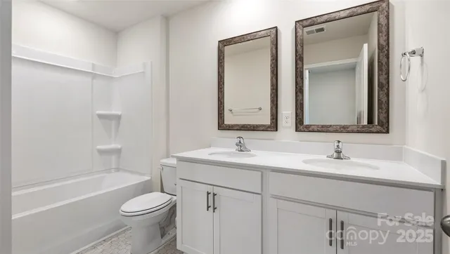 a bathroom with a toilet a sink a mirror and a bathtub
