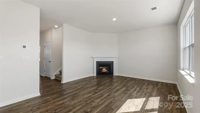 an empty room with wooden floor and fireplace