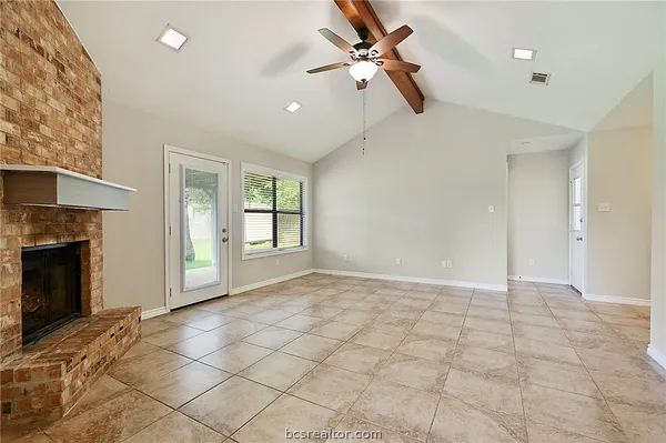 a view of an empty room with a fireplace and a window