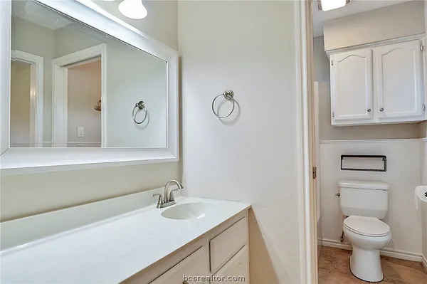 a bathroom with a sink a toilet and a mirror