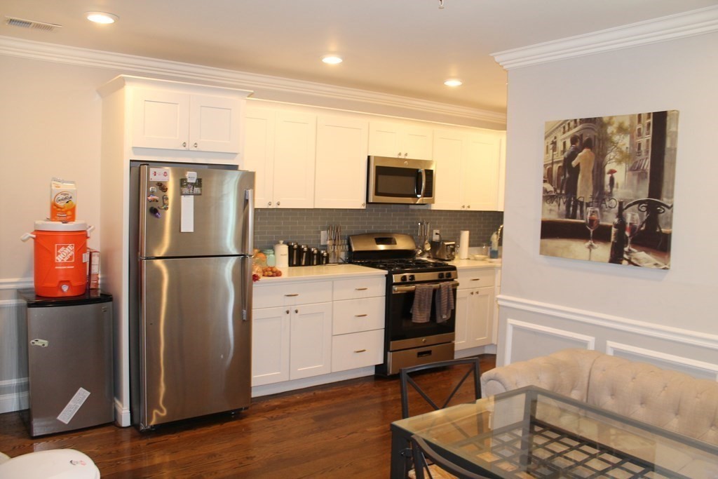 a kitchen with a refrigerator and a stove top oven