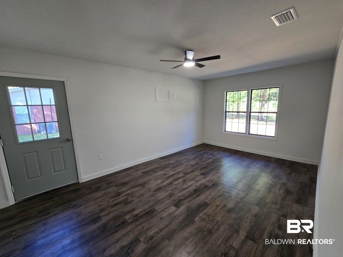 1404 Dailey Street Brewton, AL 36426 - Photo 11 of 25 Empty room with dark wood finished floors and ceiling fan