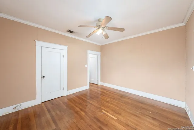 a view of an empty room with wooden floor