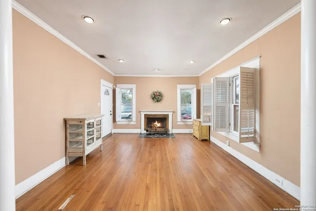a view of a livingroom with a fireplace wooden floor and window