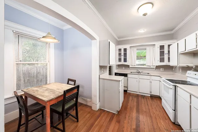 a kitchen with a table chairs sink and cabinets