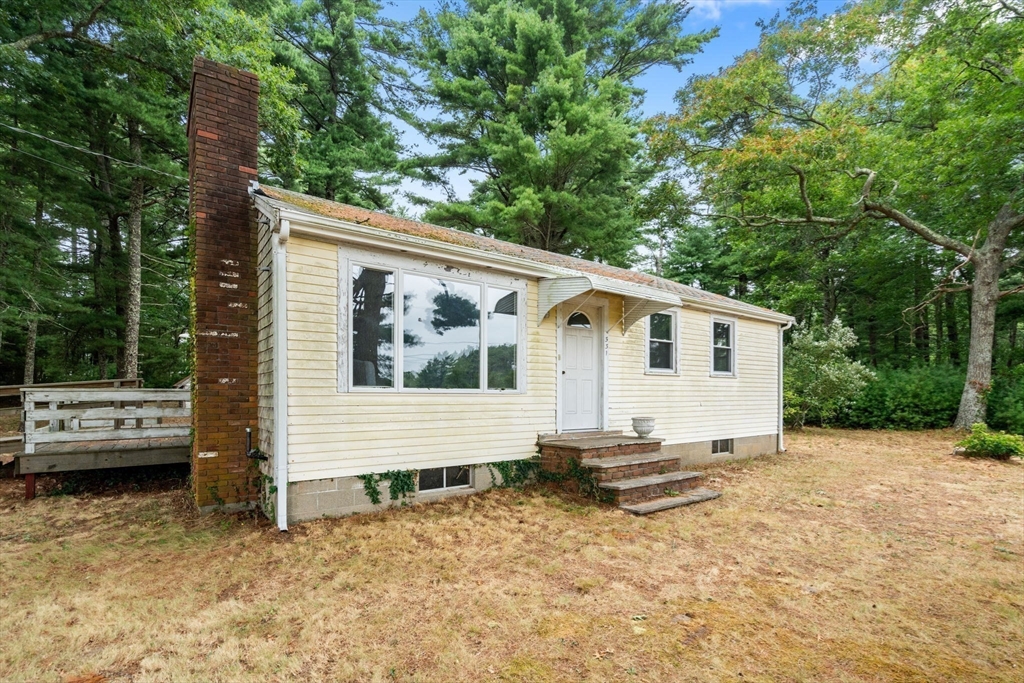 531 Marys Pond Road Rochester, MA 02770 - Photo 6 of 38 a view of a small house in a yard with potted plants