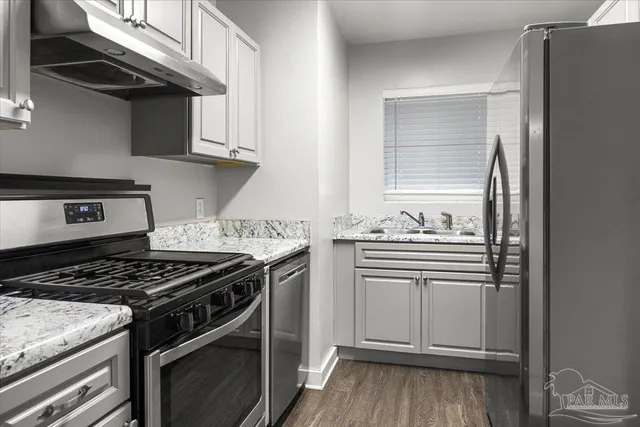 a kitchen with stainless steel appliances granite countertop a stove and a refrigerator