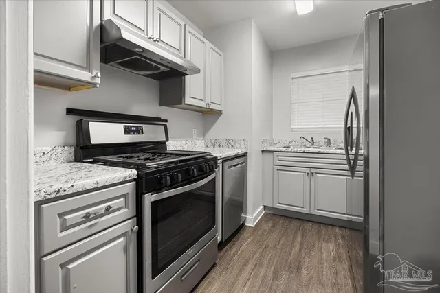 a kitchen with stainless steel appliances granite countertop a stove and a refrigerator