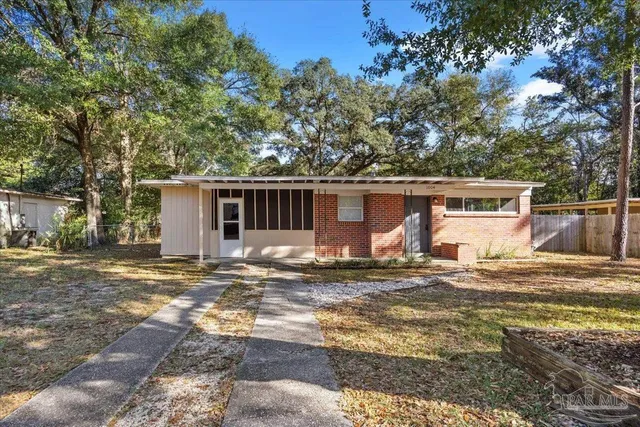 a view of a house with backyard and trees