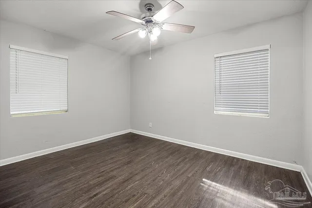 a view of a room with wooden floor and a ceiling fan