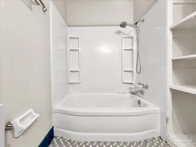 a white bath tub sitting next to a white sink