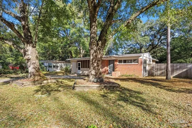 a view of a house with backyard and sitting area