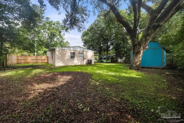 a view of a house with backyard and trees