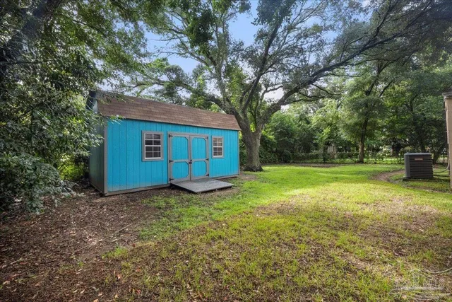 a view of a house with backyard and trees