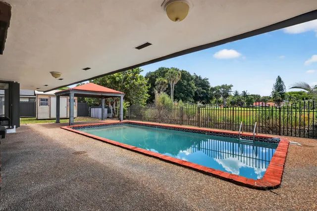 a view of swimming pool with a patio and a garden