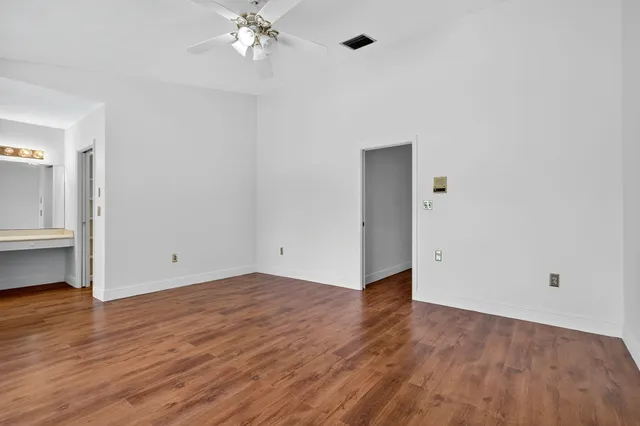 a view of an empty room with wooden floor
