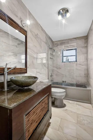 a bathroom with a granite countertop toilet a sink and bathtub