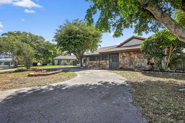 a view of road with house and trees in the background