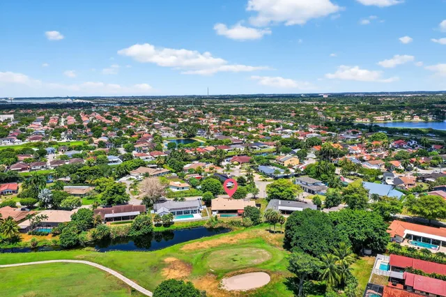 an aerial view of residential houses with outdoor space and trees