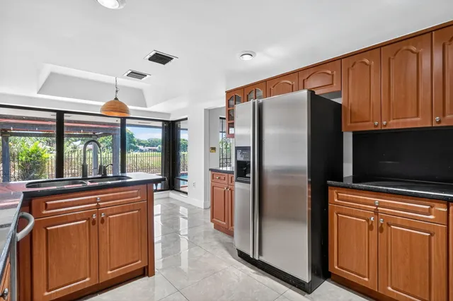 a kitchen with stainless steel appliances granite countertop a refrigerator and a stove top oven