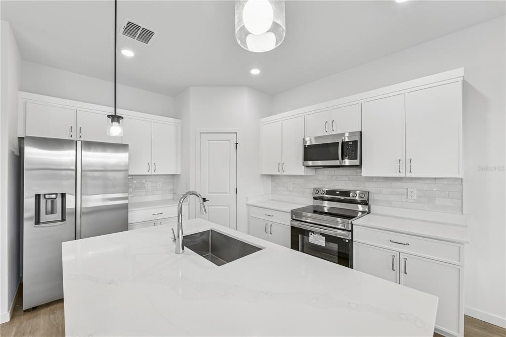 17875 Southwest 68th Place Dunnellon, FL 34432 - Photo 5 of 14 a kitchen with white cabinets and stainless steel appliances