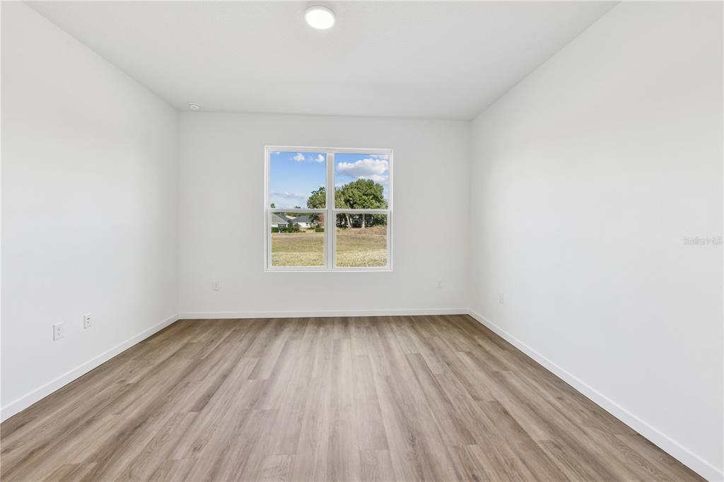 17875 Southwest 68th Place Dunnellon, FL 34432 - Photo 6 of 14 an empty room with wooden floor and windows