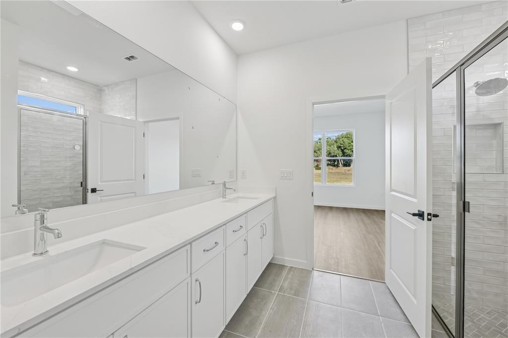 17875 Southwest 68th Place Dunnellon, FL 34432 - Photo 7 of 14 a bathroom with a double vanity sink and mirror