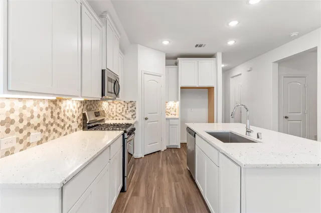 a kitchen with a sink stove and refrigerator