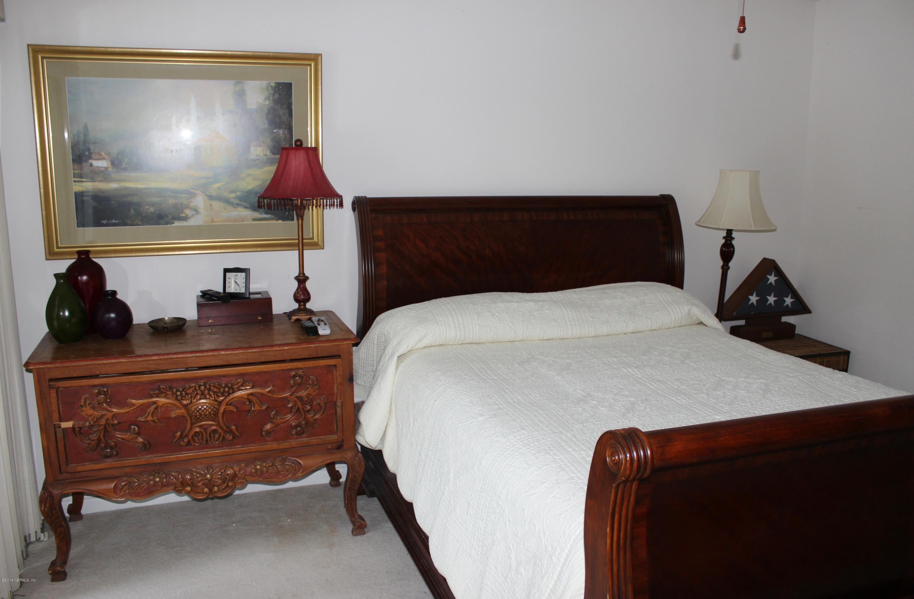 5512 Stanford Road Jacksonville, FL 32207 - Photo 14 of 22 a bedroom with a bed and a lamp on dresser
