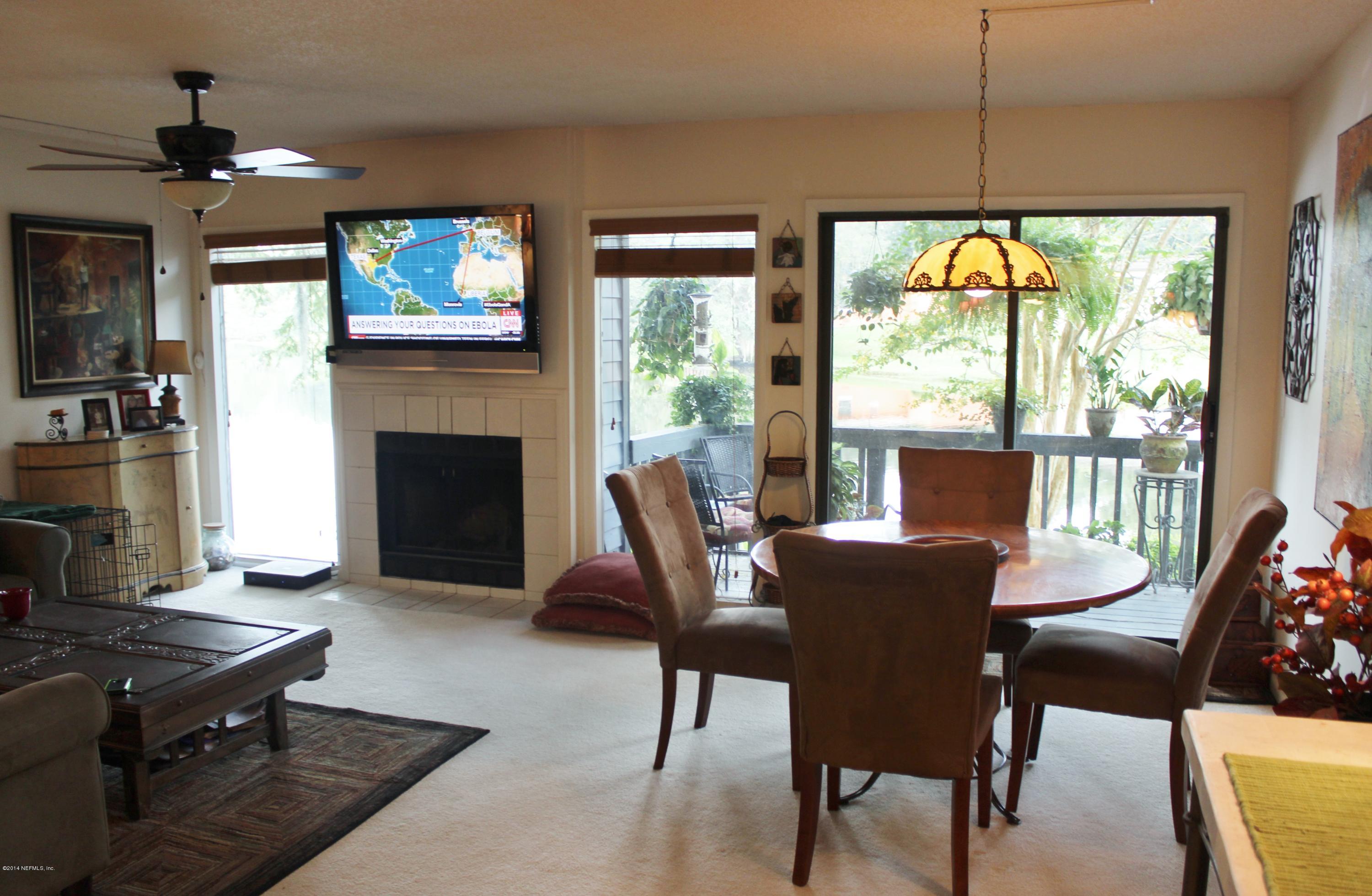 5512 Stanford Road Jacksonville, FL 32207 - Photo 5 of 22 a dining room with furniture a fireplace and large windows