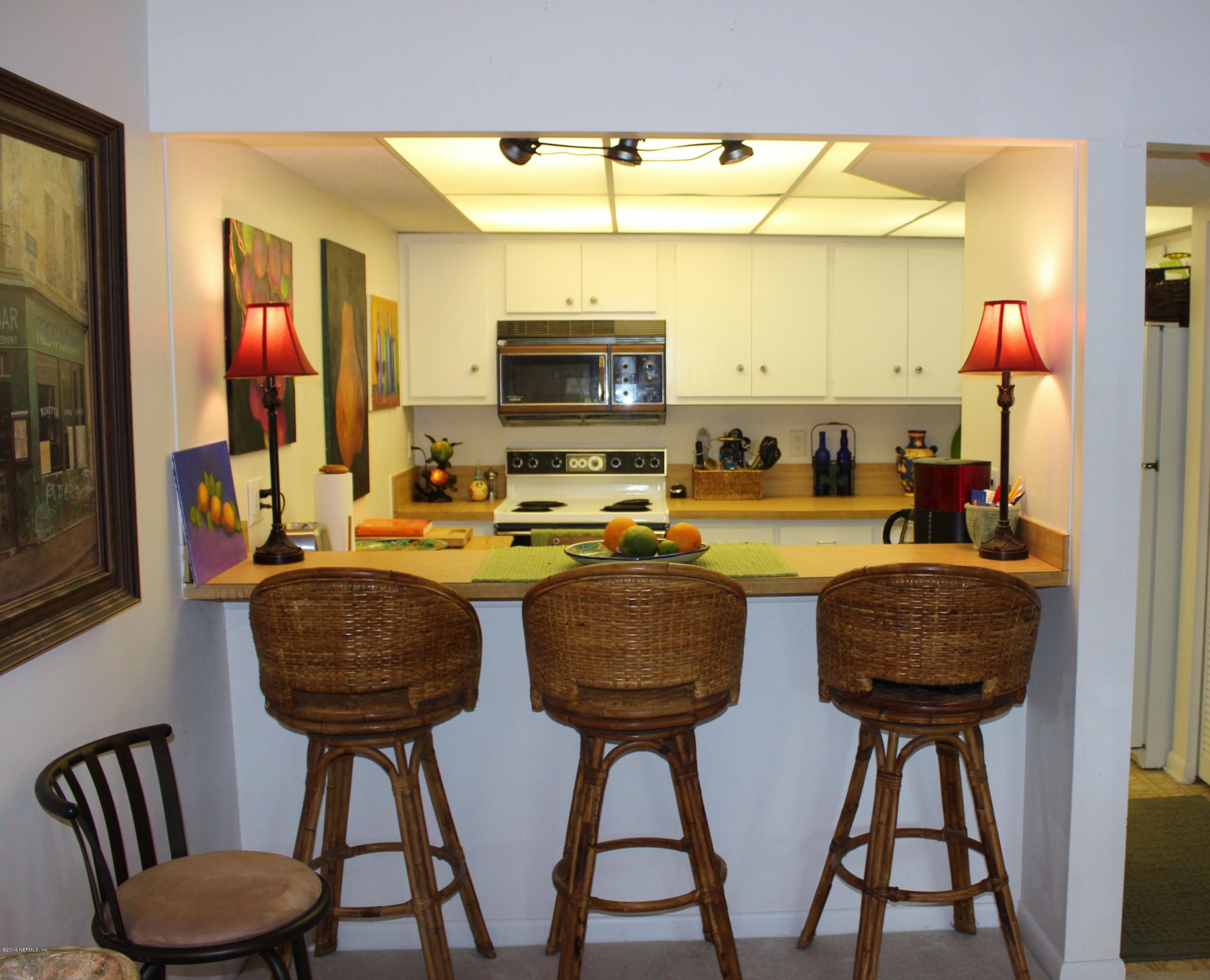 5512 Stanford Road Jacksonville, FL 32207 - Photo 9 of 22 a kitchen with stainless steel appliances kitchen island granite countertop a table chairs and a wooden floor