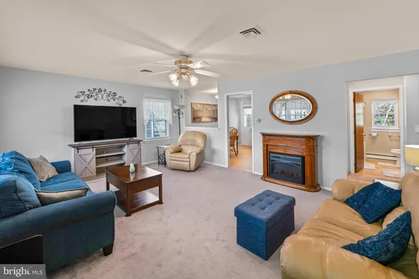 a living room with furniture a clock and a flat screen tv