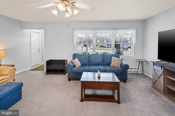 a living room with furniture a flat screen tv and a large window