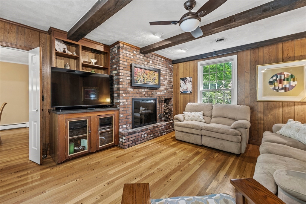 74 Brook Road Sharon, MA 02067 - Photo 15 of 32 a living room with furniture a flat screen tv and a fireplace