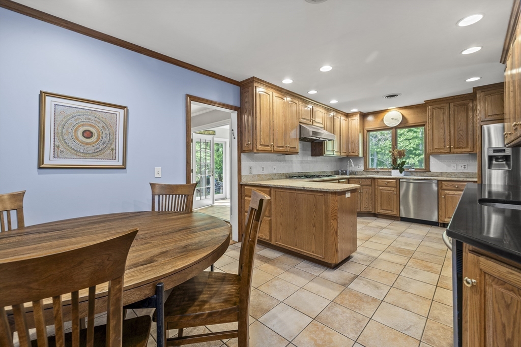 74 Brook Road Sharon, MA 02067 - Photo 6 of 32 a kitchen with a table chairs microwave and cabinets