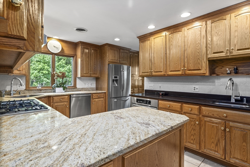 74 Brook Road Sharon, MA 02067 - Photo 8 of 32 a kitchen with stainless steel appliances granite countertop a stove a sink dishwasher and a refrigerator with wooden cabinets
