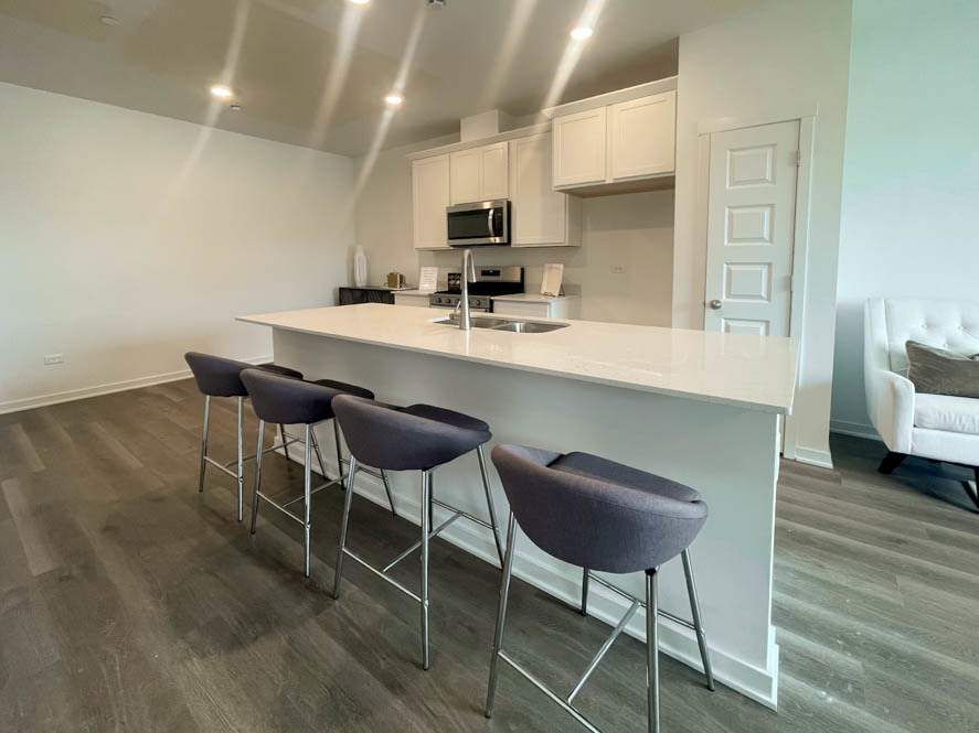2108 Bodega Drive Oswego, IL 60543 - Photo 19 of 36 a kitchen with stainless steel appliances a dining table chairs and a refrigerator