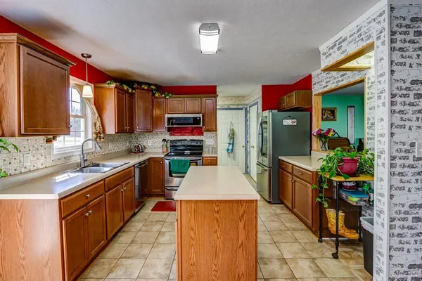 a kitchen with kitchen island granite countertop a sink window and cabinets