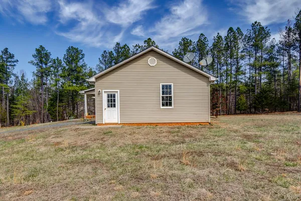 a view of a house with a yard and potted plants