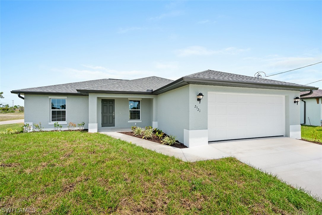 2819 37th Street Southwest Lehigh Acres, FL 33976 - Photo 1 of 14 a front view of a house with a garden and yard