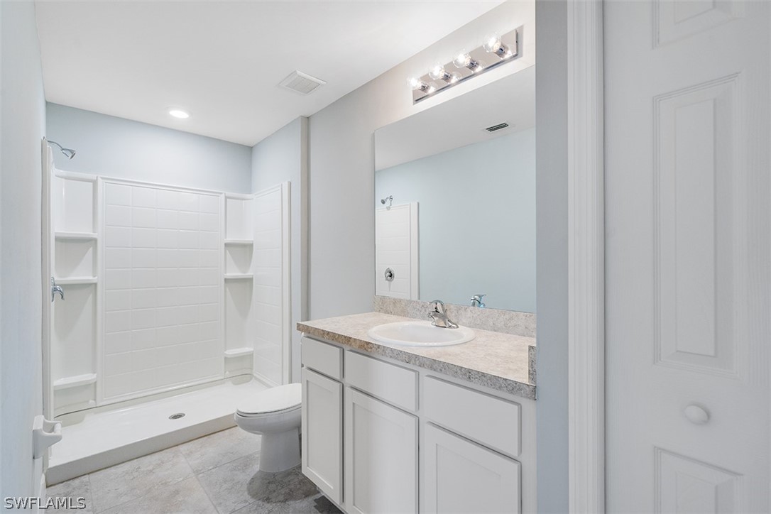 2819 37th Street Southwest Lehigh Acres, FL 33976 - Photo 12 of 14 a bathroom with a sink a toilet and shower