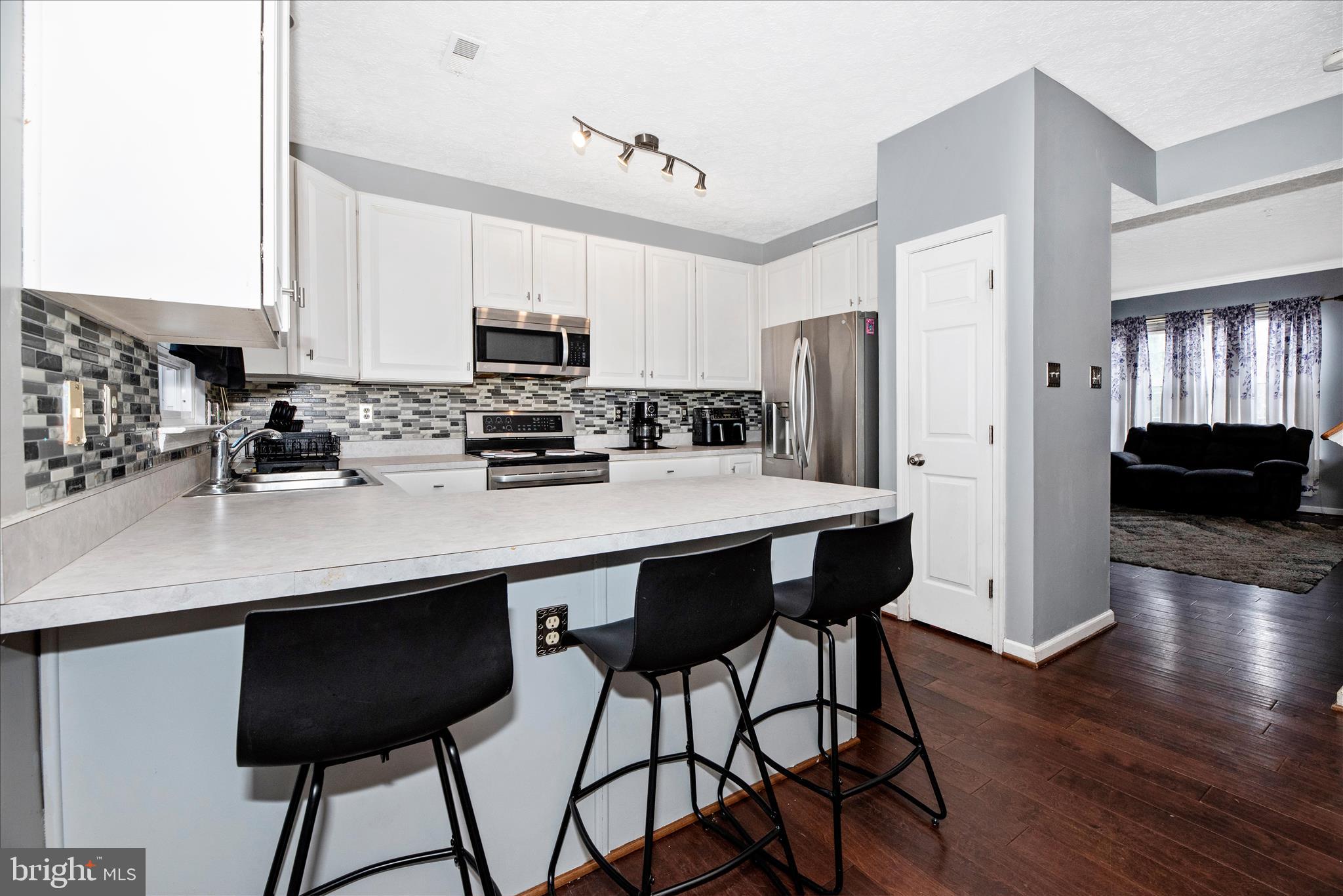 1422 Roman Ridge Way Bel Air, MD 21014 - Photo 12 of 57 a kitchen with stainless steel appliances a dining table chairs refrigerator and sink