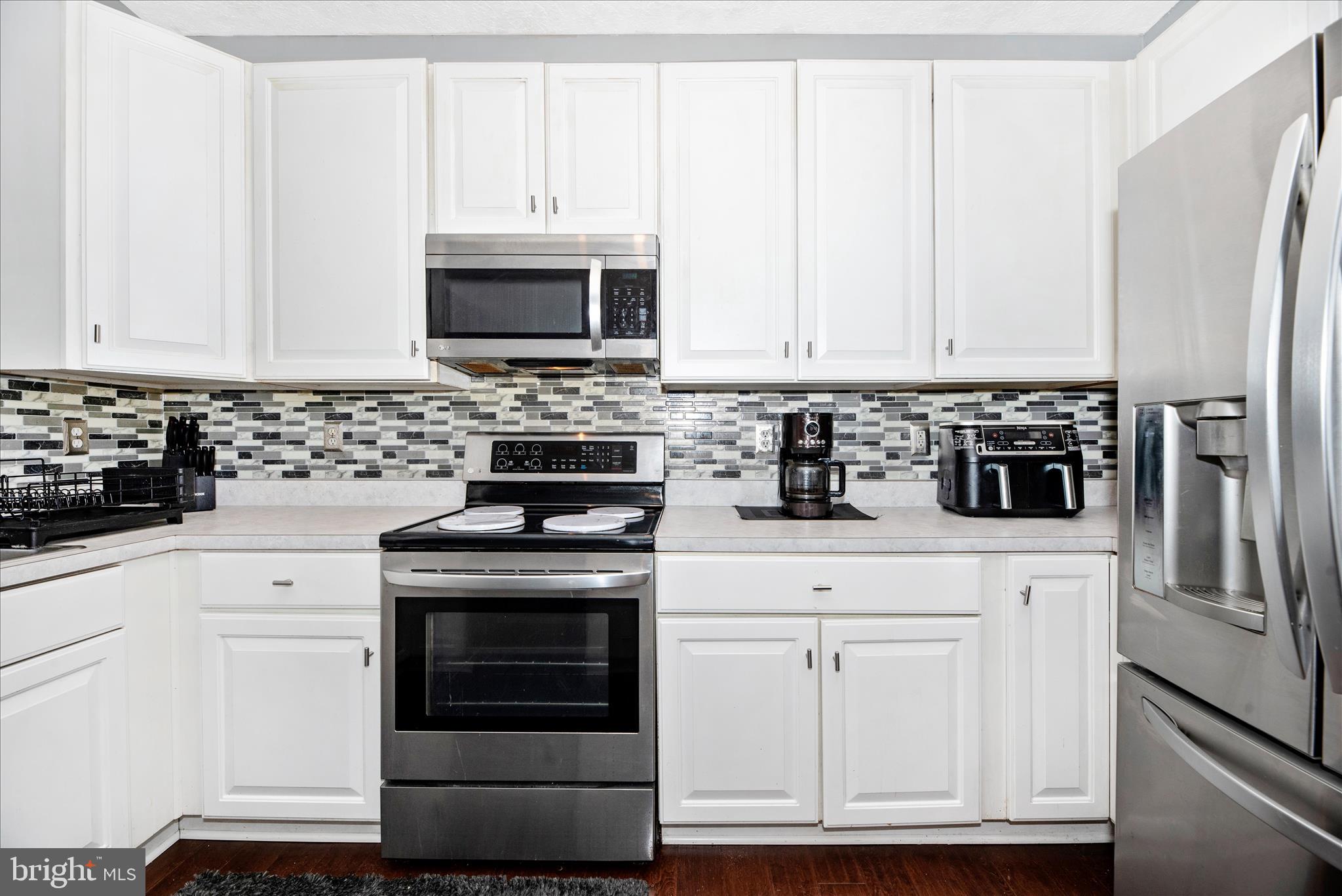 1422 Roman Ridge Way Bel Air, MD 21014 - Photo 14 of 57 a kitchen with stainless steel appliances granite countertop a stove a refrigerator and a white cabinets