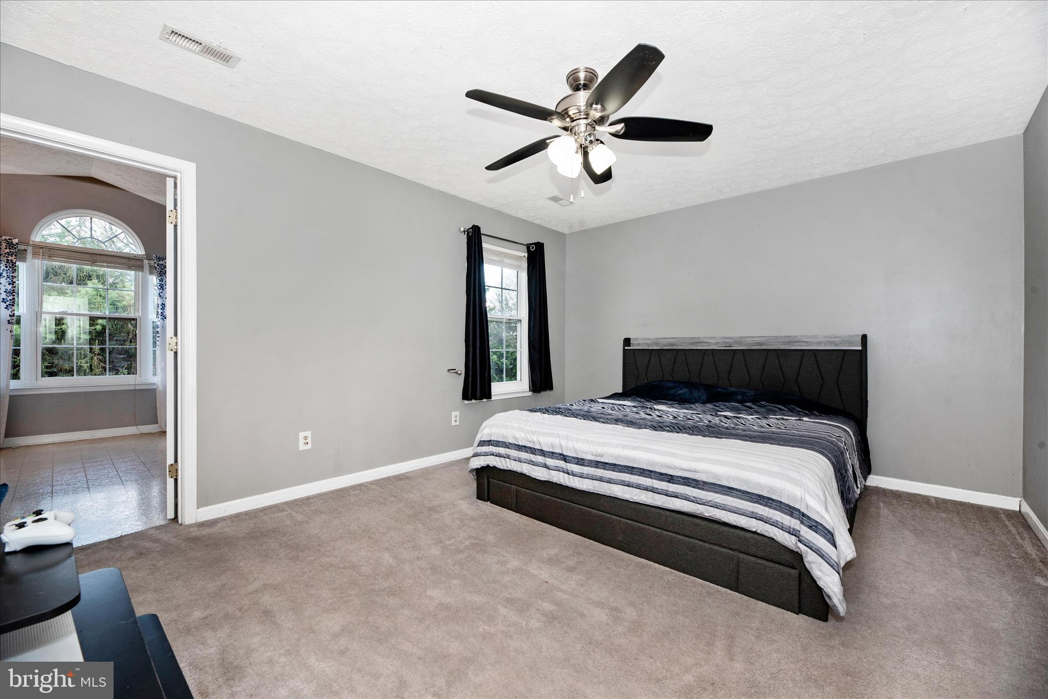 1422 Roman Ridge Way Bel Air, MD 21014 - Photo 25 of 57 a bedroom with a large bed and a chandelier