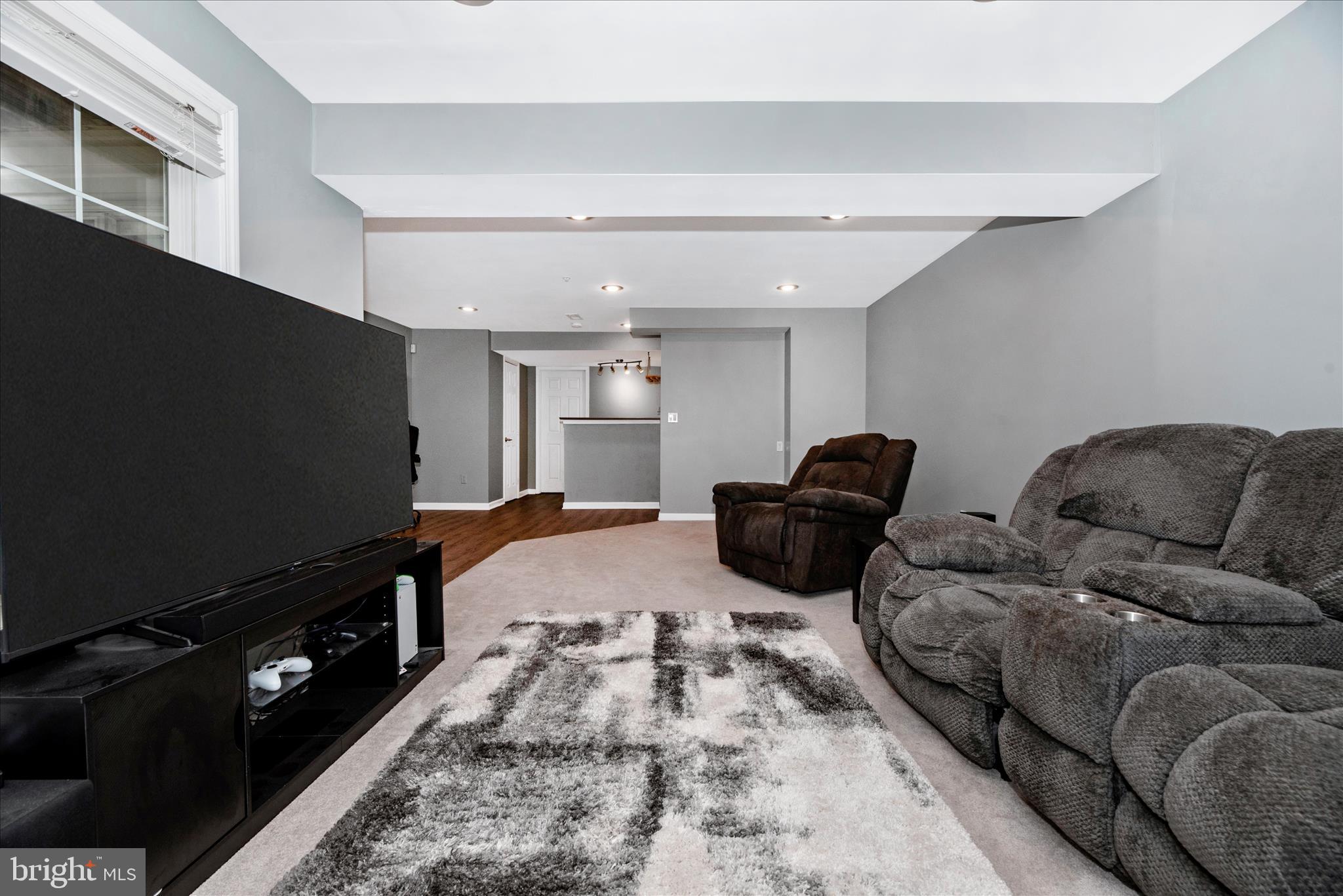 1422 Roman Ridge Way Bel Air, MD 21014 - Photo 41 of 57 a living room with furniture a flat screen tv and a refrigerator