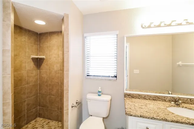 a bathroom with a granite countertop sink toilet and shower