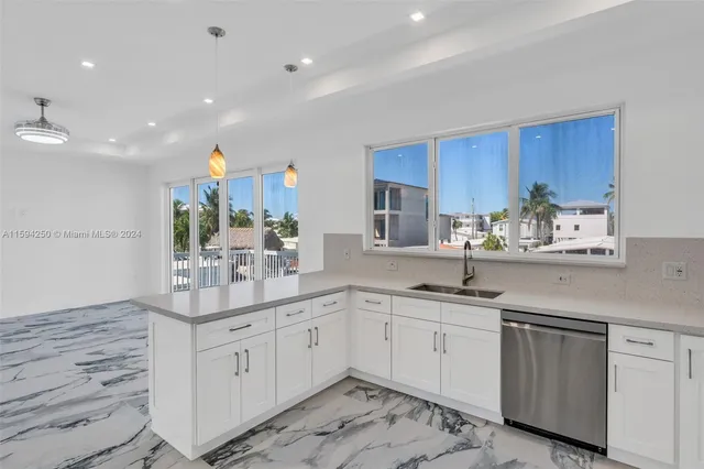 a kitchen with stainless steel appliances white cabinets and a refrigerator